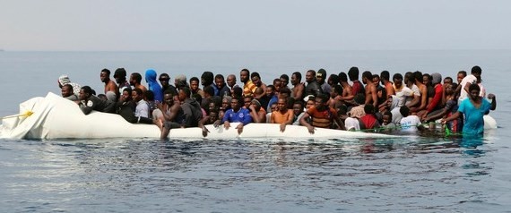 Migrants wait to be rescued from a sinking dinghy off the Libyan coastal town of Zawiyah, as they attempted to reach European shores, May 20, 2017.