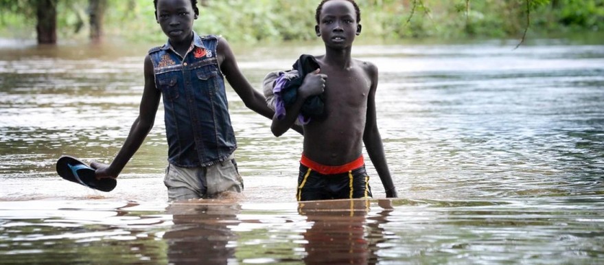 Two boys pick their way along a flooded road in Maban county, South Sudan. Photo: UNHCR/Elizabeth Stuart