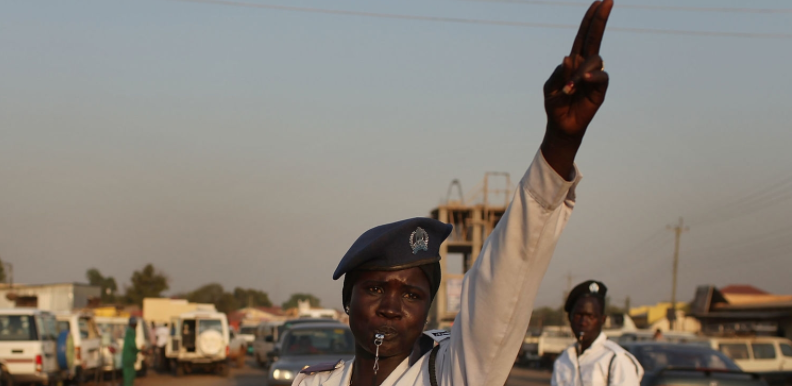 A female traffic officer directing motorists.